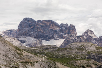 Dolomites, Italy - July, 2019: Drei Zinnen or Tre Cime di Lavaredo with beautiful flowering meadow, Sextener Dolomiten or Dolomiti di Sesto, South Tirol, Dolomiten mountains view, Italian Alps