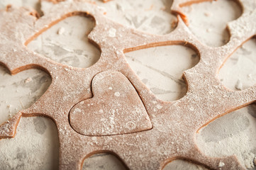 The texture of the dough closeup. Heart shaped gingerbread baking. Homemade cookies for Valentines Day and copy space. Keto baking.