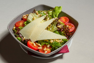 Mixed green salad with parmesan cheese in a bowl