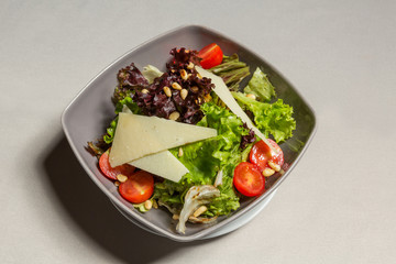 Mixed green salad with parmesan cheese in a bowl