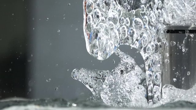 Water drops splashing on water surface. Close up of water fountain. Water jet splashing. 4K