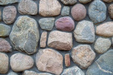 Wall background. Fragment of a colored stonewall. Natural big textured stone.