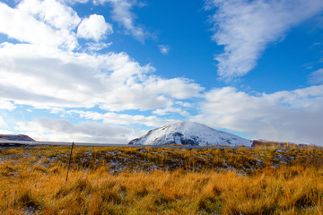 Naklejka premium road in front of small snow covered mountain