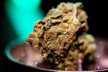 Metal grinder with marijuana, isolated on a black 