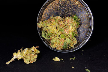 Metal grinder with marijuana, isolated on a black 