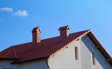 Chimneys on the roof of the house, against the blue sky