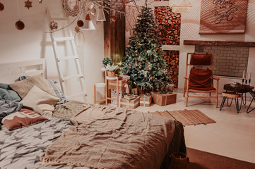 New year winter home interior. Christmas tree holiday decorations, eco gift boxes made with craft paper. White stylish cozy scandinavian style bedroom. Festive home night with muffled light