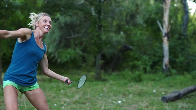 Pretty smiling sporty fitness woman emotionally Playing Badminton In Park. sport games, healthy lifestyle, slow motion fullHD stock footage.