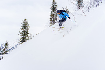 Naklejka na ściany i meble Photo of sports man with beard skiing in winter resort