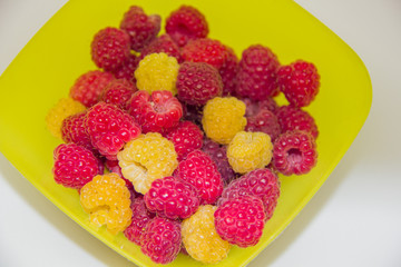 yellow and red raspberries in a yellow vest on a white background