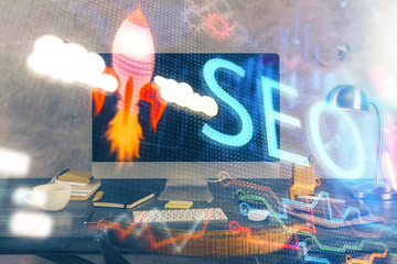 Multi exposure of table with computer and seo drawing hologram. Search optimization concept.
