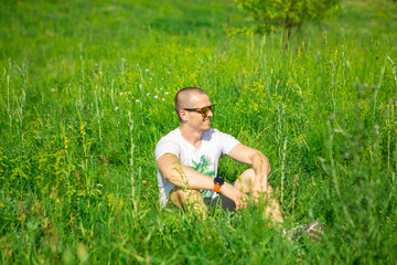 Man sitting in the grass in sunglasses