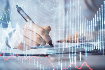 Multi exposure of woman's hands making notes with forex graph hologram. Concept stock market analysis.