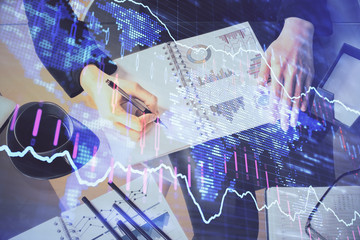 Multi exposure of hands making notes with forex chart huds. Stock market concept.