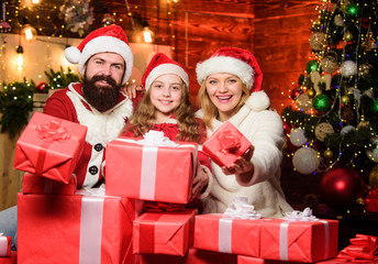 Fototapeta na wymiar Lovely daughter with parents wearing Santa hat. Togetherness concept. Love and kindness. Father Santa claus costume with family celebrating christmas. Gifts from Santa. Caring closest people
