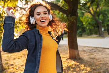 Beautiful young curly woman walking in park
