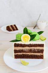 Sliced chocolate cake on a white wooden table.