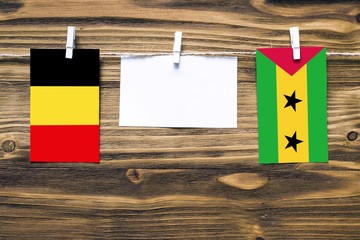 Hanging flags of Belgium and Sao Tome And Principe attached to rope with clothes pins with copy...