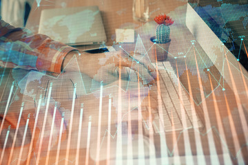 Double exposure of stock market chart with man working on computer on background. Concept of...