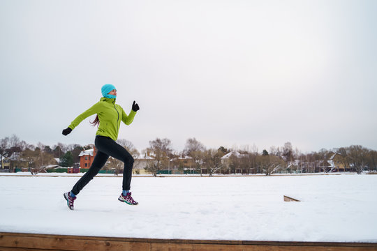 Picture of young athlete woman running in winter park