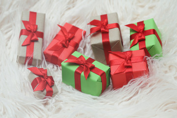 Some gift boxes wrapped in brown craft paper and tie red satin ribbon. Decorative wooden background. Your text space. Set of presents.	