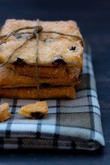 Cookies with raisins on a tablecloth with a pattern in the cell