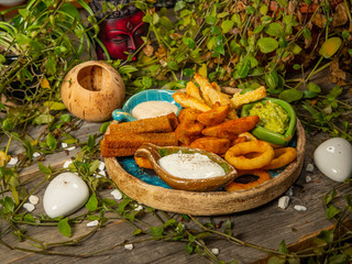 Plate with snacks for beer. French fries, cheese sticks, onion rings and white sauce