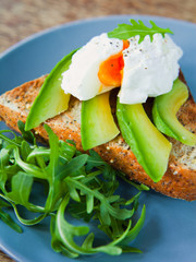 Poached Egg on Toast with Avocado and Rocket Salad.