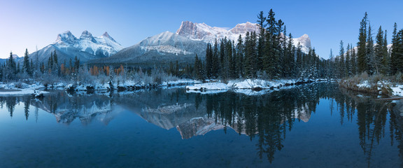 Almost nearly perfect reflection of the Three Sisters Peaks in the Bow River. Near Canmore, Alberta...