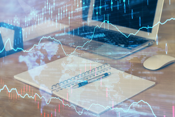 Double exposure of graph and financial info and work space with computer background. Concept of international online trading.