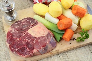 vegetables and raw meat for pot on fire on a wooden table