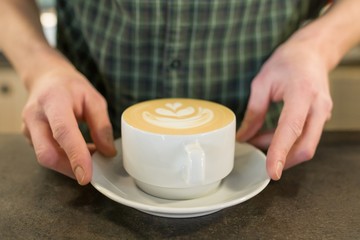 Cup of coffee art with the hands of male barista