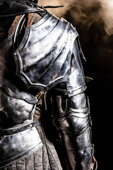 Fototapeta na wymiar cropped view of knight in armor on black background