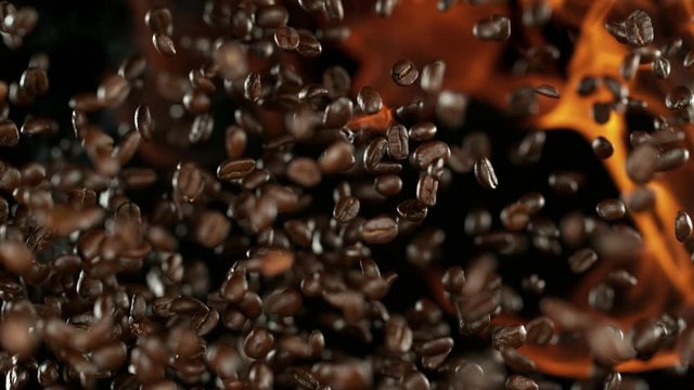 Super slow motion of flying coffee beans with flames, speed ramping effect. Filmed on high speed cinema camera, 1000 fps.