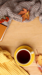 cup of hot tea or coffee, autumn flat in the Scandinavian hugg style, with yellow leaves, cozy knitwear and berries, blank for the designer, invitation, congratulations, calendar, mock up, copy space
