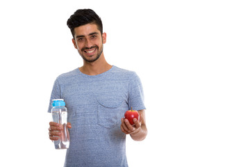 Happy Persian man smiling while holding red apple and water bottle