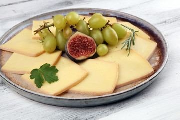 raclette cheese sliced. Very delicious swiss raclette on rustic background