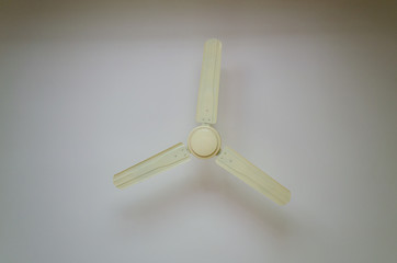 Cream colored ceiling fan on a white background