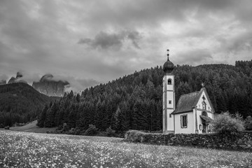 Dolomites, Italy - July, 2019: Green alpine valley with view of Santa Maddalena village church, Val di Funes, Dolomiti Mountains, Italy