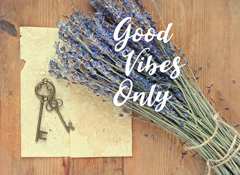 Good vibes only - text on abstract vintage romantic background. lavender flowers, bronze keys and old paper on rustic wooden background. 