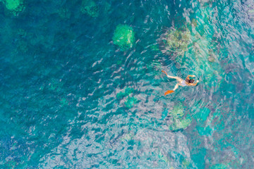 Young woman snorkeling in the blue sea.
