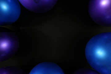 Abstract background with metallic blue and purple balloons around border with dark black copy space in middle