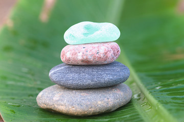 Beautiful stones pyramid on the wet banana leaf
