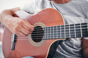 Fototapeta premium Man playing acoustic guitar in the living room.
