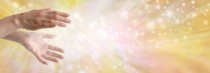 Sending out beautiful golden healing energy - female hands with sparkling white light flowing...