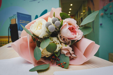 beautiful wedding bouquet with white and pink roses and other colorful flowers lying on the table close-up
