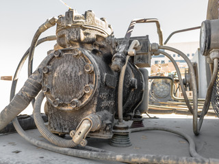closeup of an old rusty and dusty compressor of heavy duty air conditioning system kept on the roof in bright and clear sunny day
