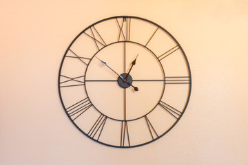 metal wire clock hanging on orange wall