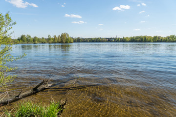 summer riverscape with blue sky, clouds and water reflections