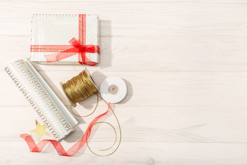 Flat lay of Christmas gifts, decoration paper, ribbons and scissors. Christmas gift concept